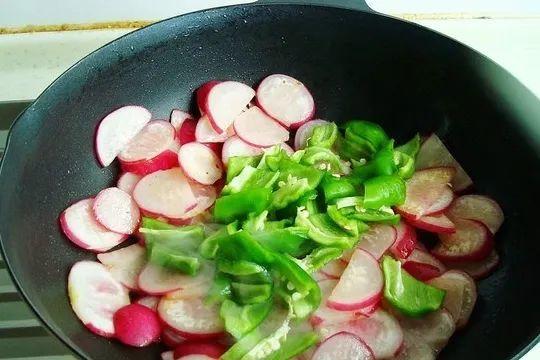 4、将蔬菜放在食物上,先在高温下进行翻炒,这样肉类经过翻炒之后才会比较嫩,如果放得太久,肉皮就会发黄熟不完全,这样也就不会非常美味啦。